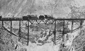 A DOUBLE-HEADED FREIGHT TRAIN crossing the slender Challape Bridge